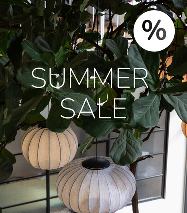 Stof pendler foran frodigt grønt med Summer Sale-besked.