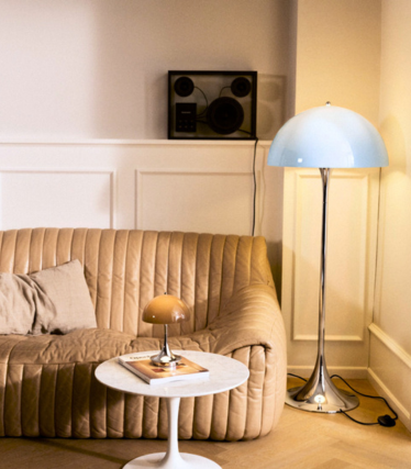 Louis Poulsen Panthella gulvlampe og bordlampe i en varm stue med lædersofa